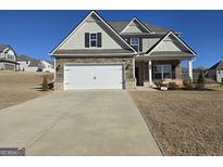 Charming home featuring stone accents, a two-car garage, and a well-manicured lawn at 1455 Weeping Tree Cir, Auburn, GA 30011