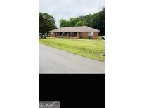 A single-story brick home with a lawn and a covered front porch at 241 E Ash St, Social Circle, GA 30025