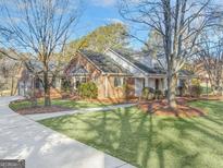 Charming brick home with mature trees, lush lawn, and a welcoming front entrance at 606 Ginger Cake Rd, Fayetteville, GA 30214