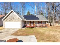 Ranch home with stone accents, solar panels, and a deck at 3076 Carriage Trl, Jonesboro, GA 30236