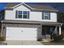 Two-story house with white siding, gray stone accents, and a two-car garage at 144 Oliver Dr, Locust Grove, GA 30248