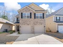 Two-story brick home with a two-car garage and landscaped front yard at 11976 Lovejoy Crossing Pl, Hampton, GA 30228