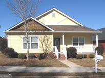 Charming yellow house with a brown roof and landscaped yard at 40 Blake Ave, Covington, GA 30014