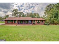 A single story brick home with a long porch and green lawn at 5225 Bailey Sw Rd, Conyers, GA 30094