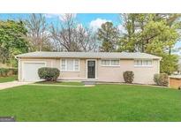 Ranch style home with a well-maintained lawn and attached garage at 348 Cologne Se Dr, Atlanta, GA 30354