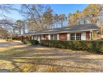 Brick ranch house with a well-manicured lawn and landscaping at 305 Kelly Dr, Fayetteville, GA 30214