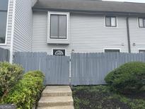 Gray siding townhouse exterior with gray gate and small landscaped yard at 233 Country Club Dr, Jonesboro, GA 30238