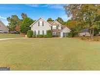 Two-story house with stone accents and a landscaped lawn at 228 Otter Cir, Fayetteville, GA 30215