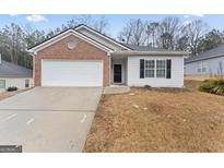 Brick and white sided home with a two-car garage and well-manicured lawn at 10231 Deep Creek Pl, Union City, GA 30291