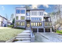 Modern three-story home with gray and white exterior, three-car garage, and concrete driveway at 2110 Fairway Ne Cir, Brookhaven, GA 30319
