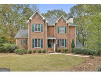 Charming brick two-story home featuring green shutters and a well-maintained front lawn at 337 Legacy Ln, Peachtree City, GA 30269