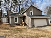 Charming two-story home with a well-maintained lawn, a garage, and a storage shed at 4163 Little Nw Spgs, Kennesaw, GA 30144