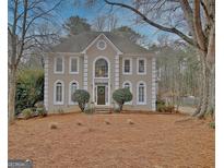 Charming two-story home features a manicured lawn, neutral stucco exterior, and inviting front entrance with decorative wreath at 112 Windalier Rdg, Peachtree City, GA 30269