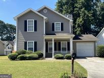 Charming two-story home with gray siding, black shutters, a front porch, and manicured landscaping at 5425 Twin Lakes Dr, Atlanta, GA 30349
