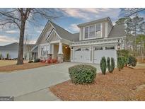 Charming home with a two-car garage, inviting front porch, and beautiful landscaping at 220 Brock Ct, Fayetteville, GA 30215