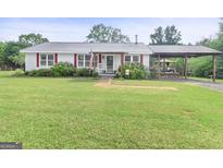 Charming one-story home featuring a metal roof, a cozy front porch and covered carport at 382 Lamb Rd, Moreland, GA 30259