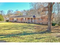 Charming brick home with a lush front yard, welcoming stone accents, and a cozy front porch at 185 Redwood Cir, Fayetteville, GA 30214