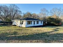 Cozy single-story home featuring white siding, large windows, and a welcoming ramp entrance at 225 Bell St, Covington, GA 30016