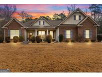Charming single-story home featuring a well-manicured lawn and beautiful brick and siding exterior at 144 Caraway Rd, Locust Grove, GA 30248