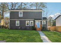 Charming two-story home featuring a well-maintained lawn and a welcoming blue front door at 2046 Arlington Nw Cir, Atlanta, GA 30318
