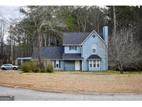 Charming two-story home featuring a classic blue exterior, complemented by a dark roof and a neatly maintained front yard at 3281 Nina Way, Douglasville, GA 30135