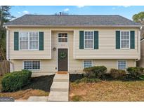 Charming home showcasing the front door with wreath, green shutters, and well-maintained landscaping at 111 Hamilton Rd, Peachtree City, GA 30269