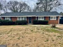 Charming red brick ranch-style home with trimmed bushes in front yard at 2037 Mesa Se Dr, Atlanta, GA 30316