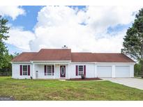 Charming single-story home with a well-manicured lawn, red shutters, and a covered front porch at 153 Cedar Ridge Rd, Locust Grove, GA 30248