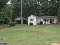 Charming single-story home with a welcoming front porch and a spacious, well-manicured front yard at 2421 Rockbridge Sw Rd, Stone Mountain, GA 30087