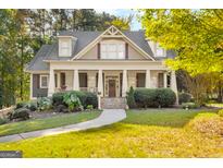 Charming home with a welcoming front porch, landscaped yard, and beautiful architectural details at 101 Kenmare Row, Tyrone, GA 30290