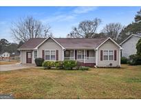 Charming single-story home with neutral siding, red shutters, a brown roof, and manicured landscaping at 3645 Fay Dr, Rex, GA 30273
