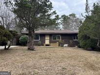 Charming single-story home with mature trees and a cozy, inviting facade at 10173 Brass Ring Rd, Jonesboro, GA 30238