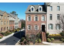 Charming townhome featuring a brick facade, dormer windows, and inviting entry stairs at 6422 Paulson, Atlanta, GA 30328