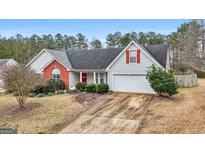 Charming single-story home features a red brick accent, landscaped yard, and attached two-car garage at 40 Berkshire Run, Covington, GA 30016