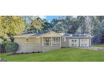 Charming ranch-style home featuring a welcoming front porch, grey brick facade, and lush green lawn at 2846 Cocklebur Rd, Decatur, GA 30034