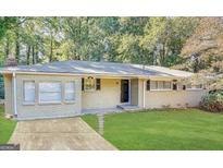 Charming brick home featuring a well-manicured lawn and welcoming front entrance, complete with lovely landscaping at 3647 Brookcrest Cir, Decatur, GA 30032