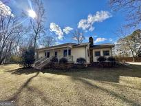 Charming home featuring a welcoming front porch and well-maintained yard with a brick trim at 1450 Victoria Ln, Oxford, GA 30054