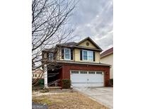 Charming two-story home with a brick facade, two car garage, and covered porch on a cloudy day at 2517 Oakleaf Rdg, Lithonia, GA 30058