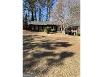 Charming single-story brick home with a well-maintained front yard and mature trees at 1125 Carlo Sw Ct, Atlanta, GA 30331