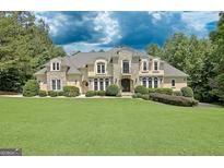 Beautiful home with a manicured front lawn and a combination stone and siding facade at 709 Prestige Pt, Peachtree City, GA 30269