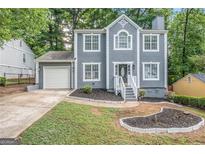 Charming two-story home with attached garage, well-manicured lawn, and gray paint at 2986 Cascade Manor Dr, Decatur, GA 30034