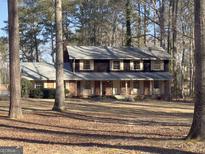 Charming two-story home featuring a brick facade, symmetrical design, and mature trees in a serene setting at 3140 Jodeco Dr, Jonesboro, GA 30236