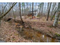 Secluded home featuring a stream running through the front yard and a bridge leading to the property at 613 Rock Springs Pass, Dallas, GA 30157