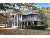 Charming two-story home featuring a large front yard, covered porch, and beautiful, mature trees at 1954 Saybrook Ct, Jonesboro, GA 30236