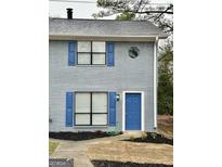 Charming two-story home with light-blue painted brick, blue shutters, and a well-manicured front yard at 1309 Lakeview Nw Dr, Conyers, GA 30012