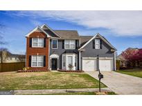 Charming two-story home with a brick and gray siding exterior, two-car garage, and well-maintained lawn at 3028 Hallman Cir, Marietta, GA 30064
