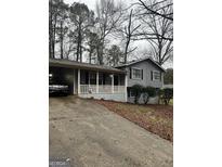 Charming home featuring a welcoming front porch and a convenient carport at 9055 Kelly Ct, Jonesboro, GA 30236