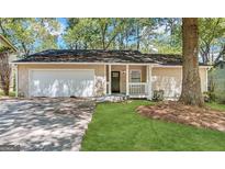 Charming single-story home with a garage, front porch and manicured lawn at 5468 Pepperwood Ct, Stone Mountain, GA 30087