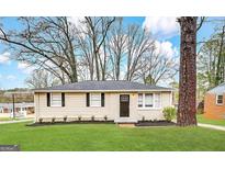 Charming single-story home featuring a well-manicured lawn, complemented by freshly laid mulch at 360 Belgarde Pl, Atlanta, GA 30354