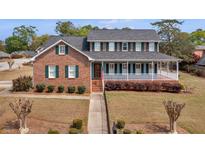 Two-story brick home with a large, welcoming front porch and well-maintained landscaping at 135 Oakpark Ter, Mcdonough, GA 30253